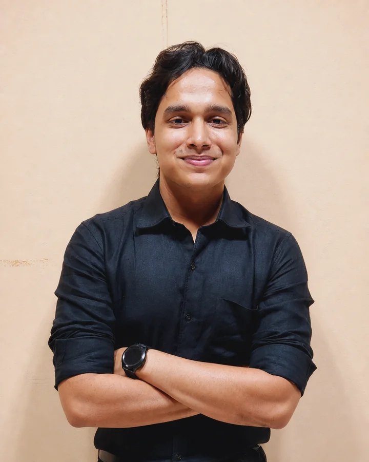 Atishay Jain in a black shirt, smiling with his arms crossed